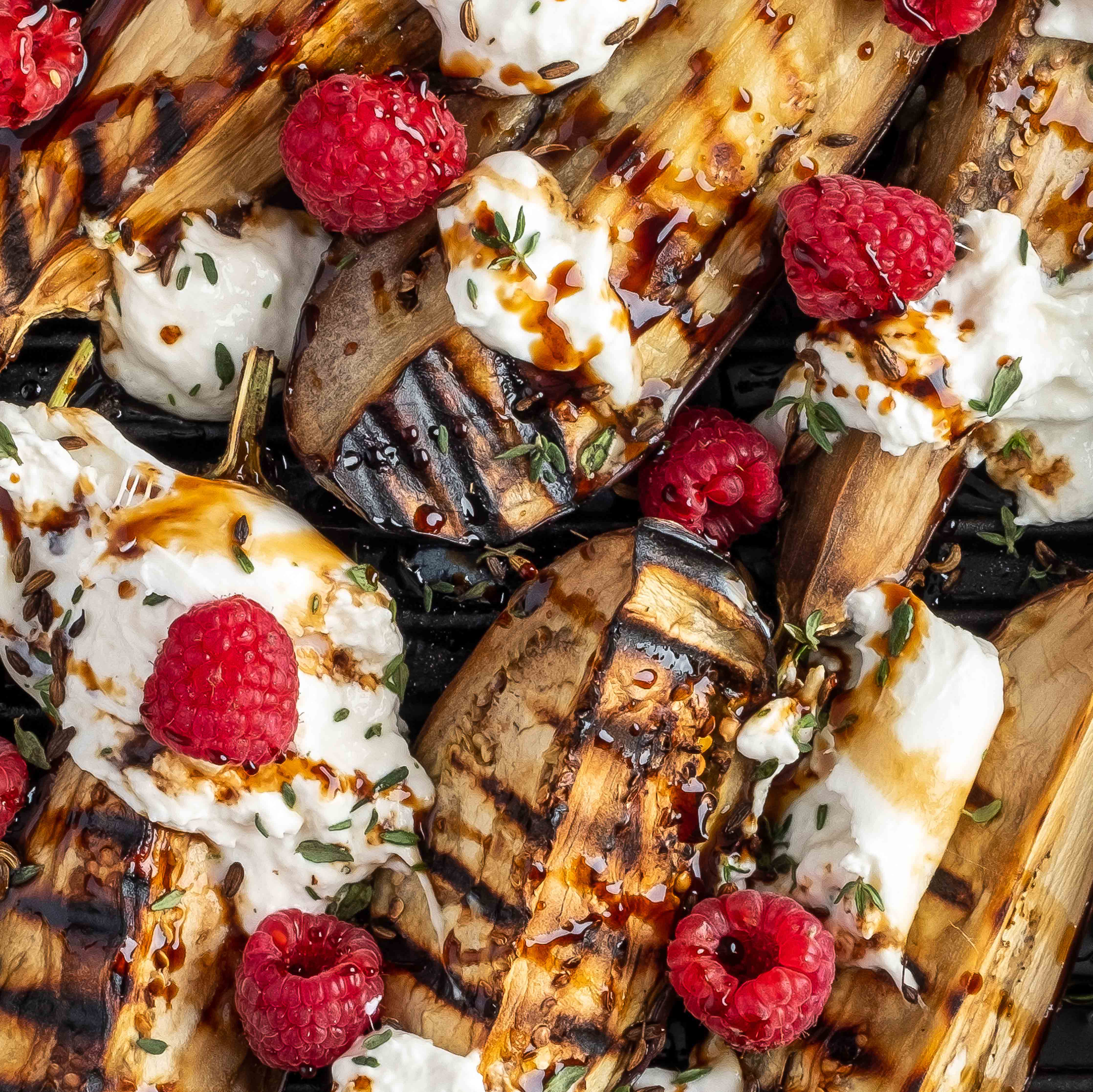 Gegrillte Auberginenspalten mit Burrata und Himbeeren bedeckt