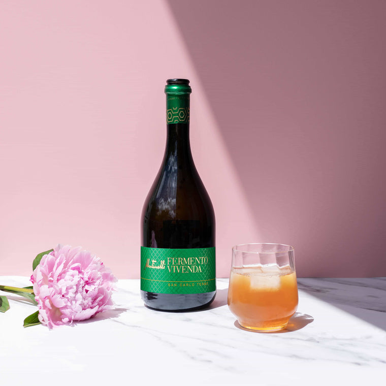 Stimmungsbild der Fermento Vivenda vor Rosa Hintergrund mit einem Glas