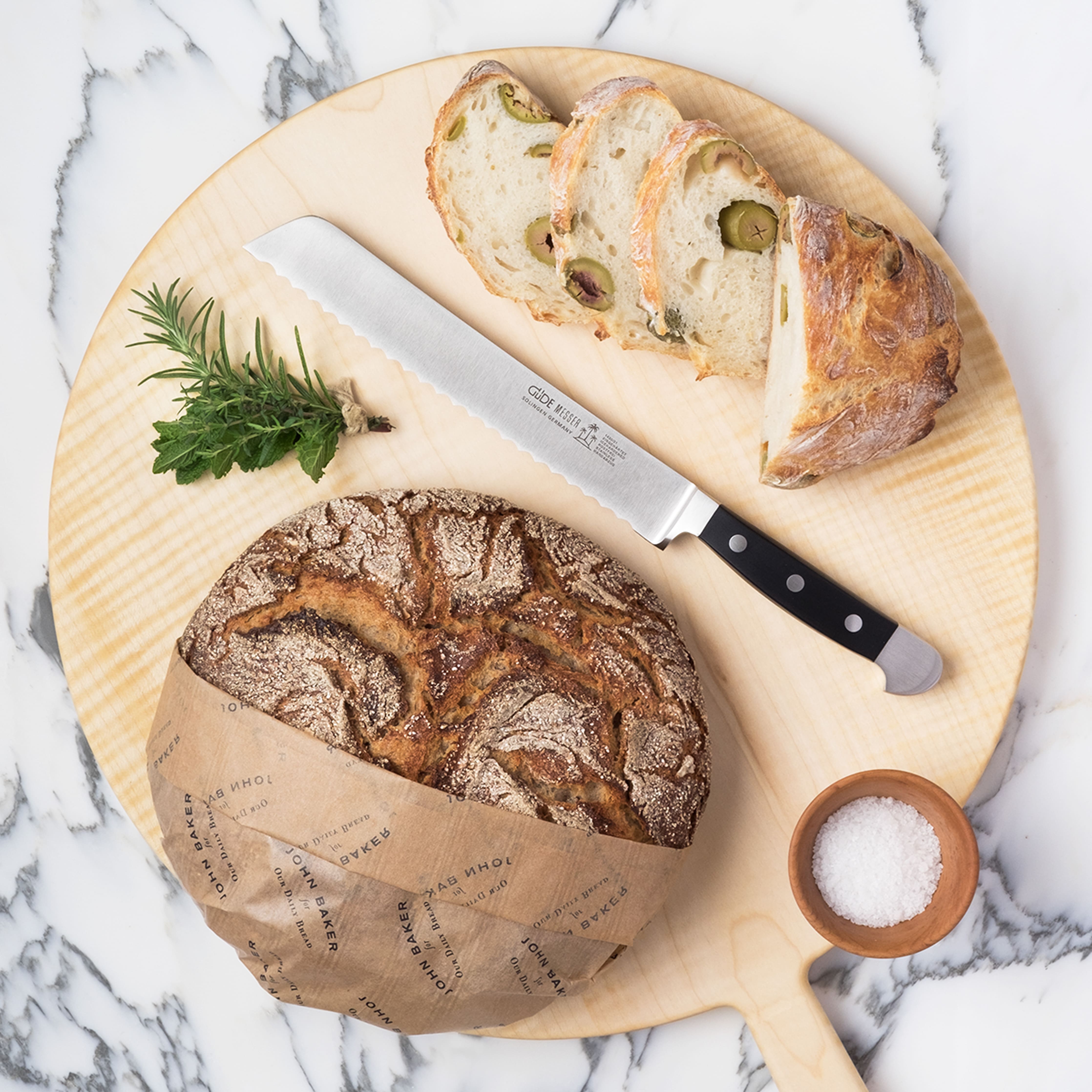 mood: Moodaufnahme des Güde Alpha Brotmesser platziert zwischen frischem Brot