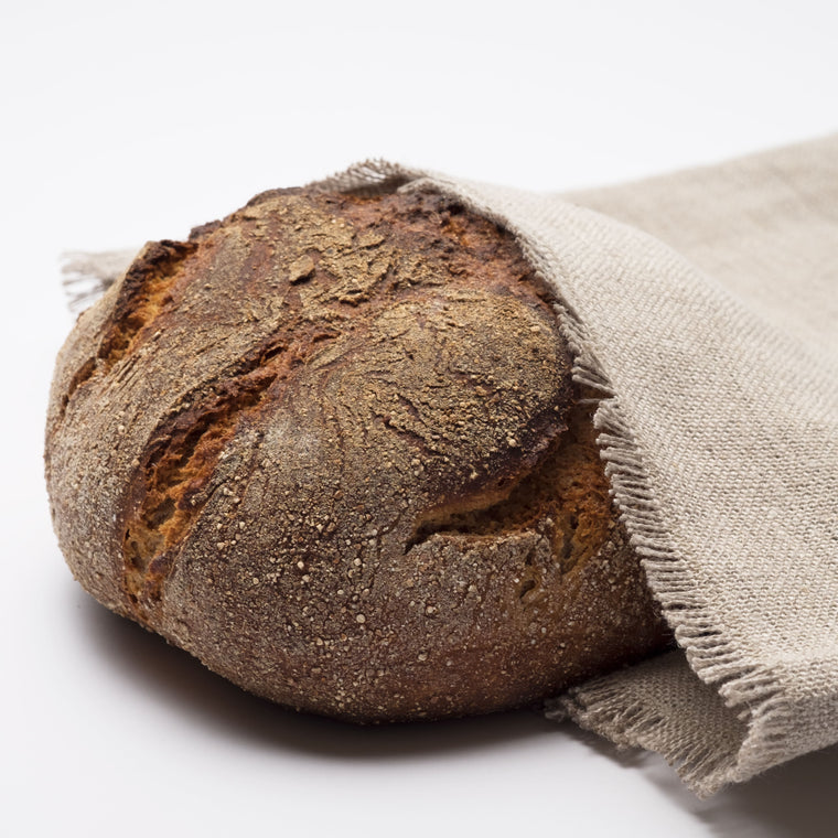 Detailaufnahme eines Brotes das zur Hälfte im John Bakers Brotsack liegt