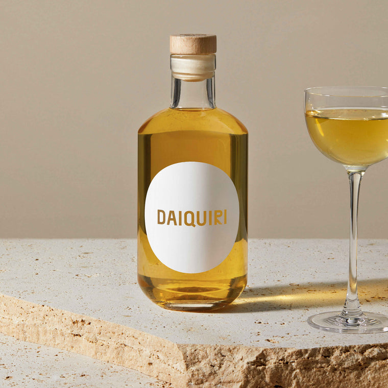 Stimmungsbild der Daiquiri Flasche auf Travertin neben einem Cocktailglas mit Daiquiri