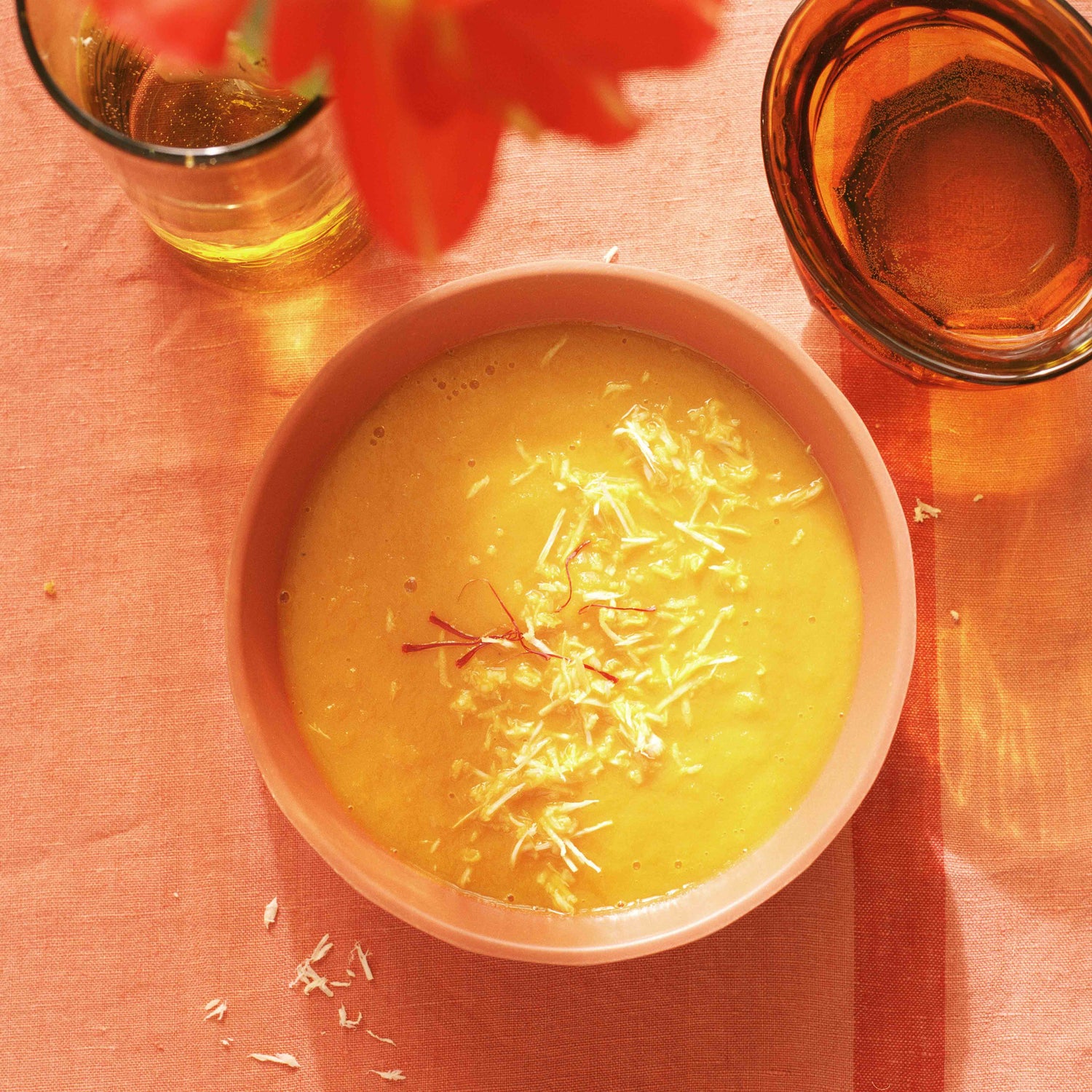 Eine Rüeblisuppe mit frischem Meerrettich und Safran als Vorspeise mit einem honigfarbenen Glas aus Syrien