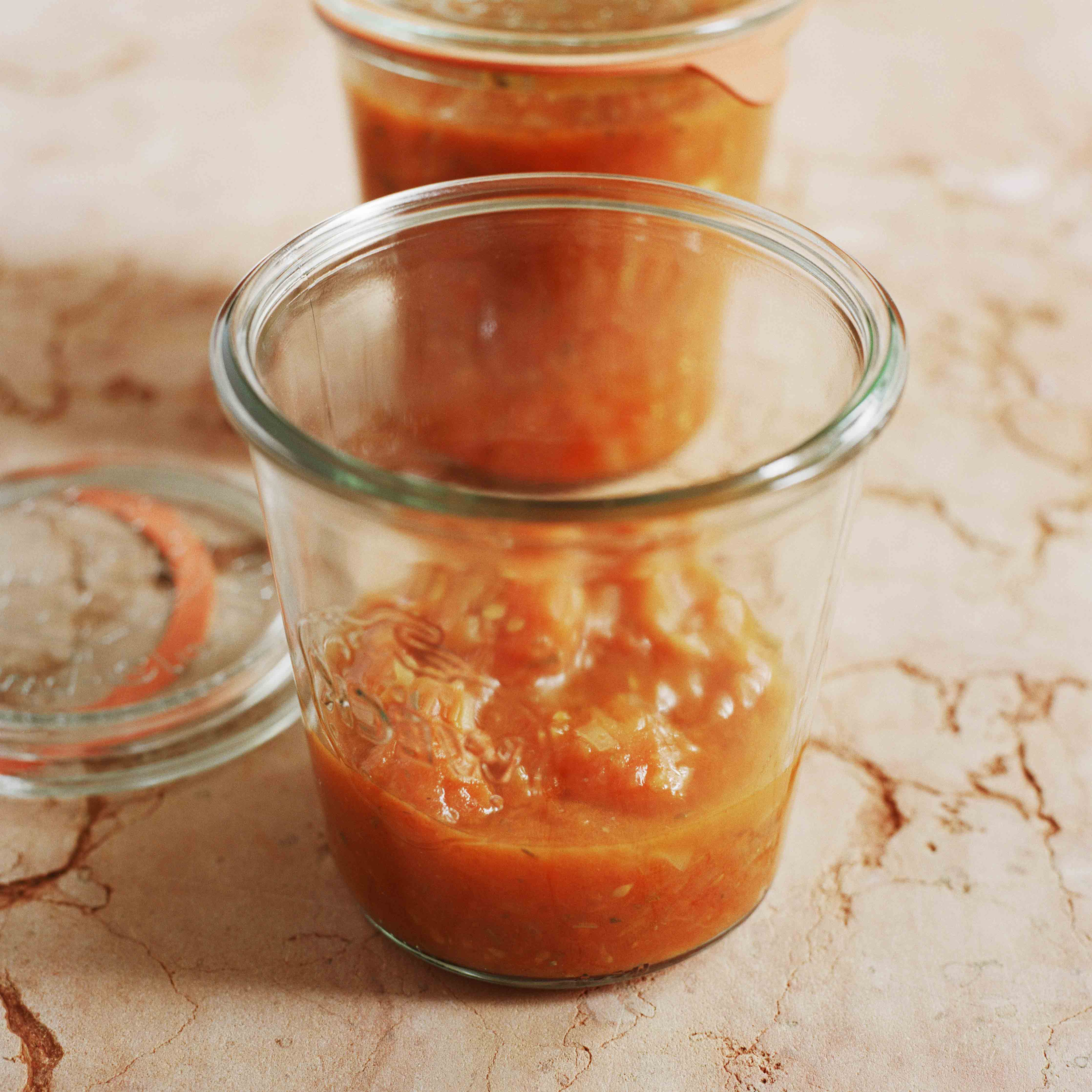Ein Sugo aus Tomaten abgefüllt in je ein offenes und ein geschlossenes Einmachglas von Weck