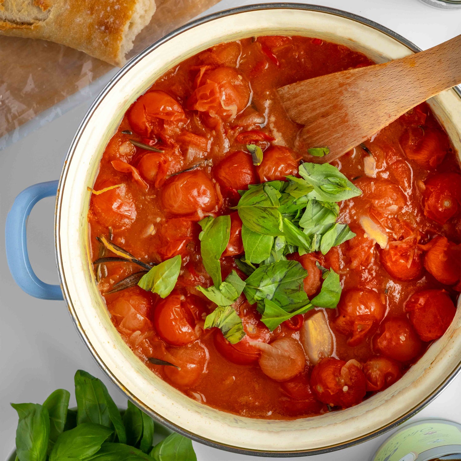 Runder Topf mit Tomatensugo aus Cherrytomaten garniert mit Basilikum