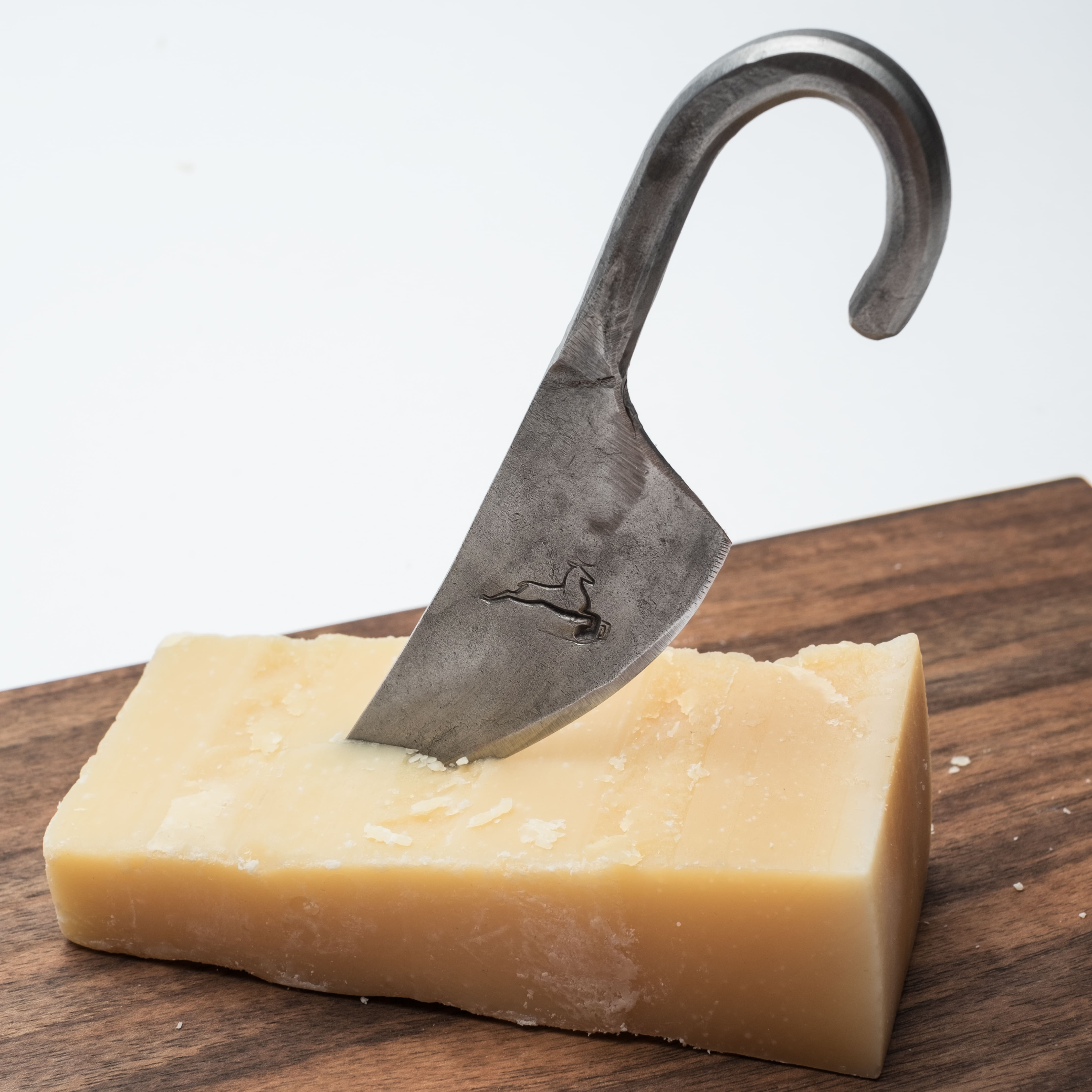 mood: Moodbild des handgeschmiedeten Alp-Sbrinzmessers eingestochen in den Sbrinz auf einem Nussholzbrett