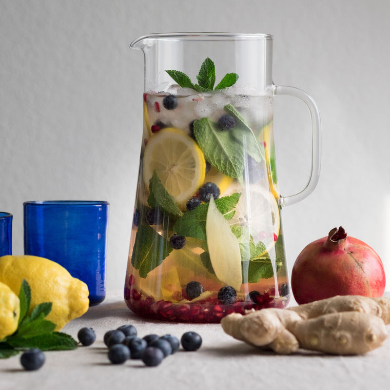Moodbild des gefüllten Glaskrug aus Borosilikatglas mit Eistee und frischen Früchten