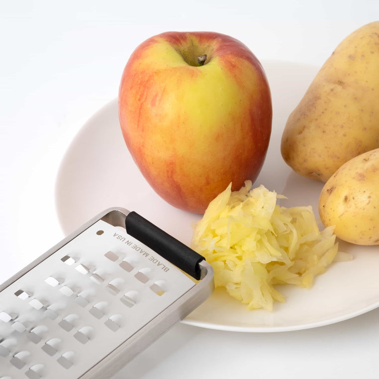 Anwendungsbeispiel der Raffel mit einem Apfel und einer Kartoffel