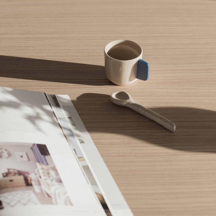 Moodbild einer Espressotasse von Studio Sediment auf dem Frühstückstisch mit Zeitung