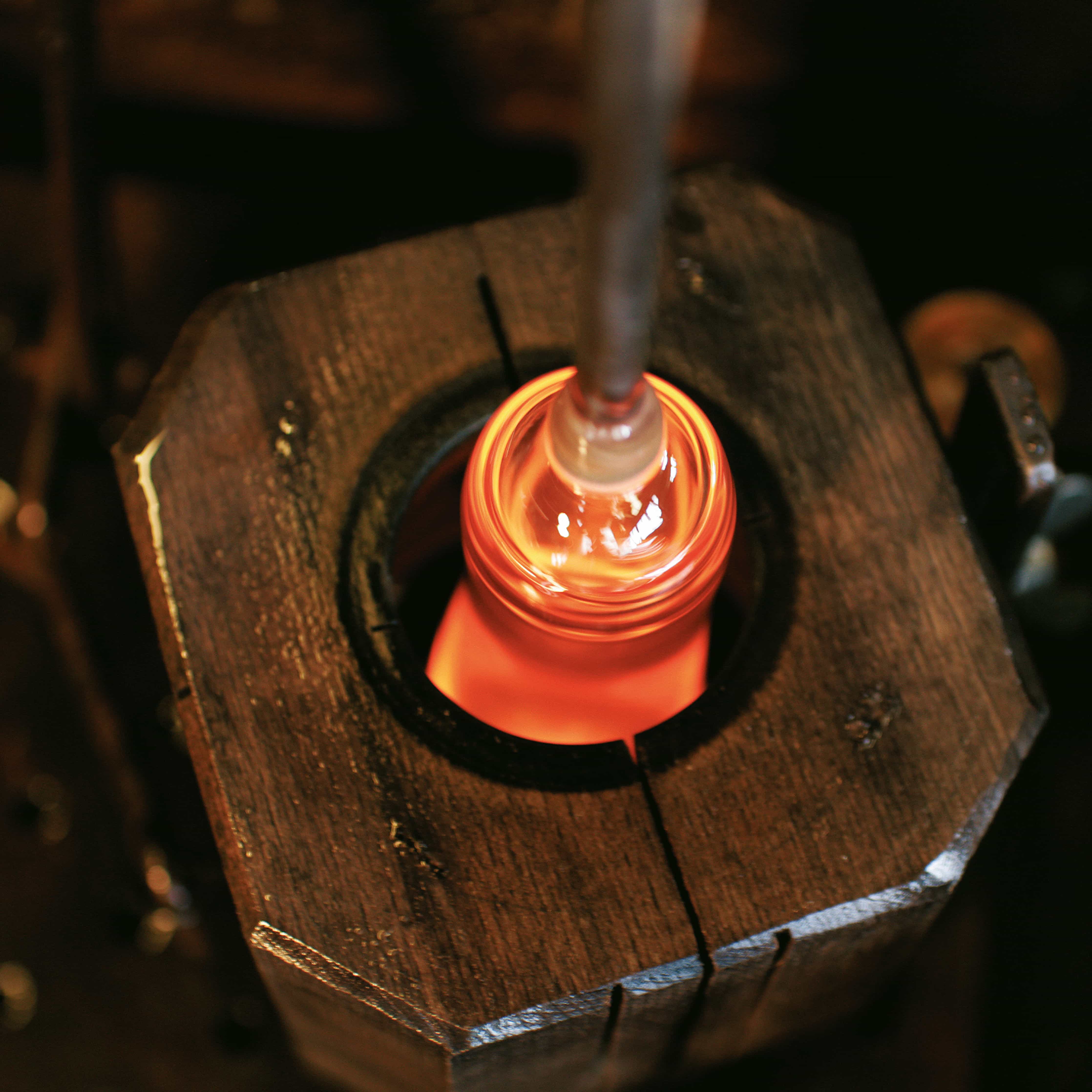 mood: Glasbläser der Manufaktur Zalto blasen flüssiges Glas in eine nasse Holzform ein
